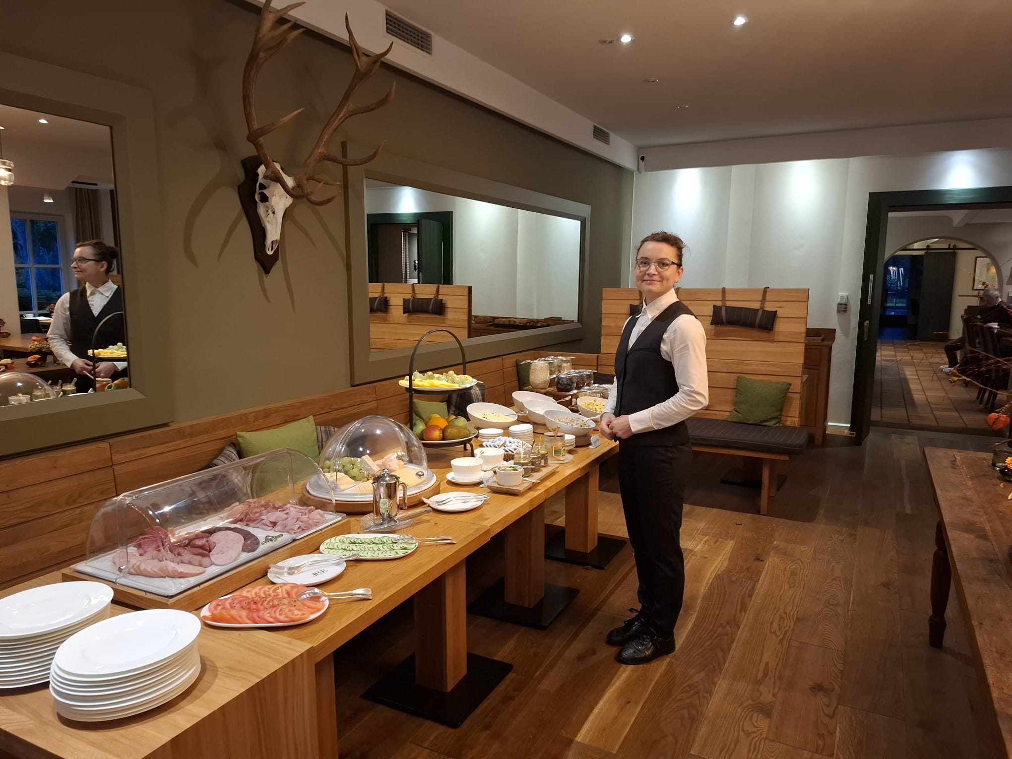 Frühstücksbuffet bei Rüssels Landhaus mit einer Mitarbeiterin im rechten Teil des Bildes